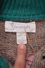 Load image into Gallery viewer, Label of beige sweater is shown up close. It reads &quot;Stonesgate, mens size S, 100% wool.&quot;
