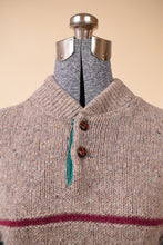 Load image into Gallery viewer, Front of beige sweater is shown close up. The sweater has two brown buttons at the neck.
