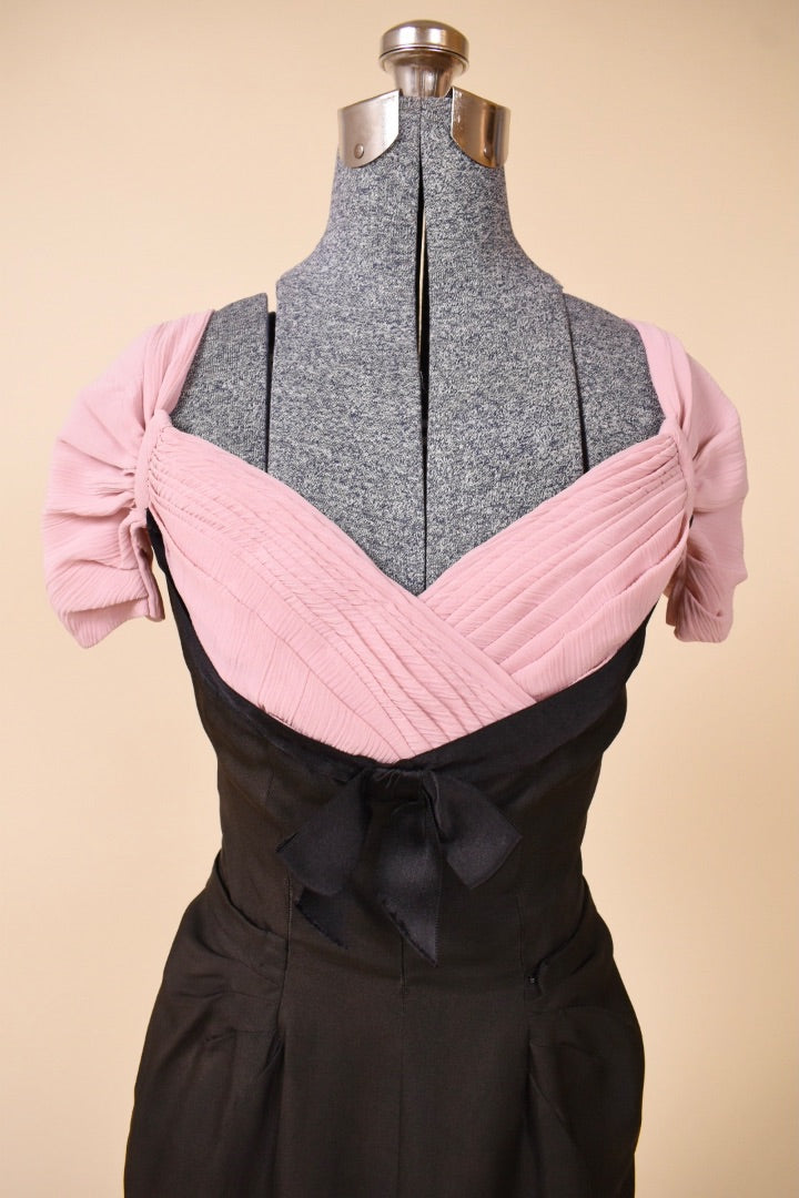 Black and pink dress top is shown up close. The dress has a pleated chest.