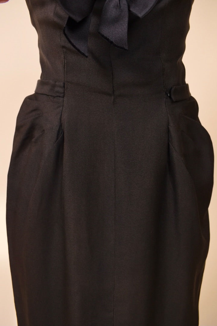 Lower front of black and pink dress is shown up close. The lower front features darts for shape.