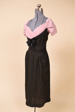 Load image into Gallery viewer, Black and pink dress is shown from the side. The sleeves are pleated.
