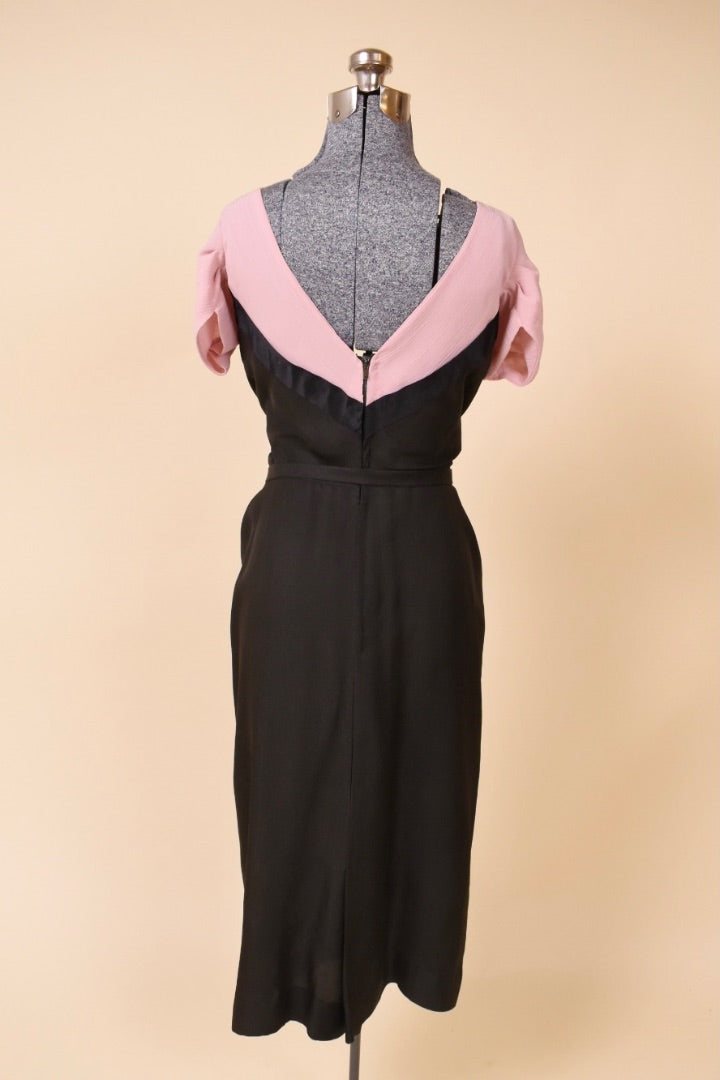 Black and pink dress is shown from the back. The dress has a v-neck back.