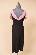 Load image into Gallery viewer, Black and pink dress is shown from the back. The dress has a v-neck back.
