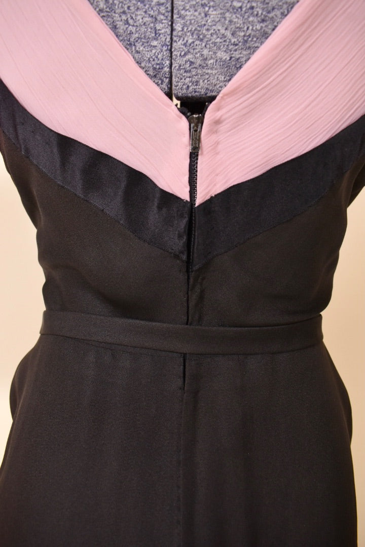 Zipper of black and pink dress is shown up close. The zipper is metal.