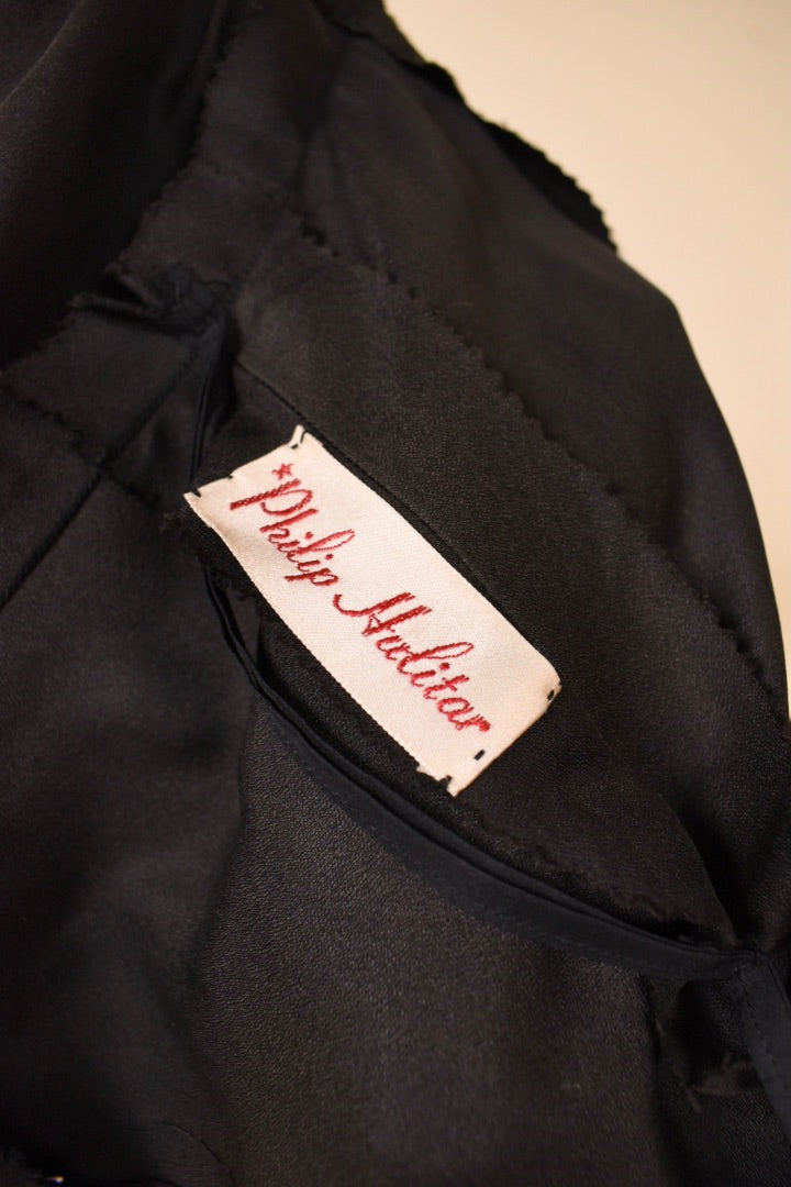 Label of the black and pink dress is shown up close. The label says Philip Hulitar.