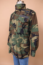 Load image into Gallery viewer, The jacket is angled to the left. The piece is slightly cinched at the waist. A lower left pocket and upper left pocket are visible.
