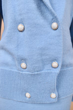 Load image into Gallery viewer, Vintage seventies baby blue wool sweater is shown in close up. This sweater has six white circular buttons on the front.
