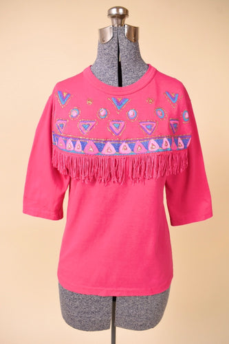 Vintage hot pink 1980s puffy paint top is shown from the front. This shirt has a western inspired fringe across the chest.