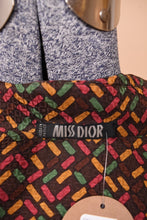 Load image into Gallery viewer, The inside shirt tag is visible up close. The tag reads, Miss Dior.
