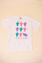 Load image into Gallery viewer, Vintage 1980&#39;s pink, purple, and green cactus and lizard graphic Arizona tee shirt is shown from the front. 
