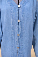 Load image into Gallery viewer, Vintage light wash blue denim button down is shown from the front. This button down top has iridescent circle buttons. 
