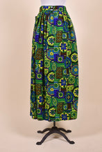 Load image into Gallery viewer, Vintage green and yellow seventies patchwork print maxi length skirt is shown from the back. 
