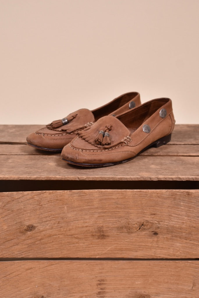 Vintage 1990s tan leather concho and tassel loafers by Jones New York are shown from the side. 