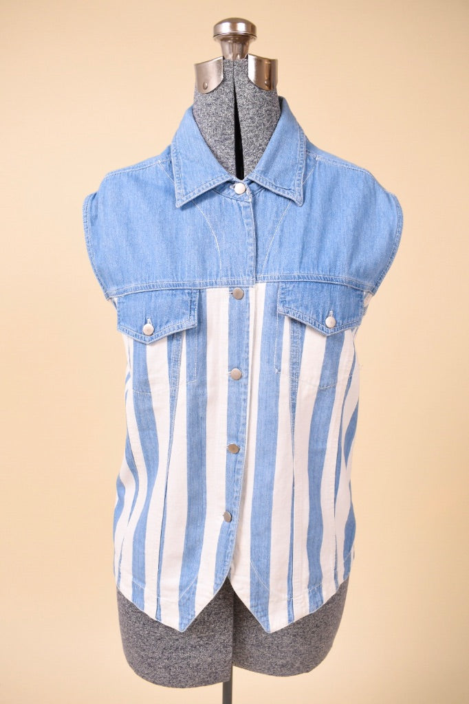 Vintage white and blue vertical stripe sleeveless denim top is shown from the front. This 90s sleeveless button down has two pockets at the bust. 