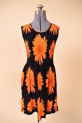Vintage Y2K black and orange smocked sundress is shown in close up. This dress has a scooped neck.