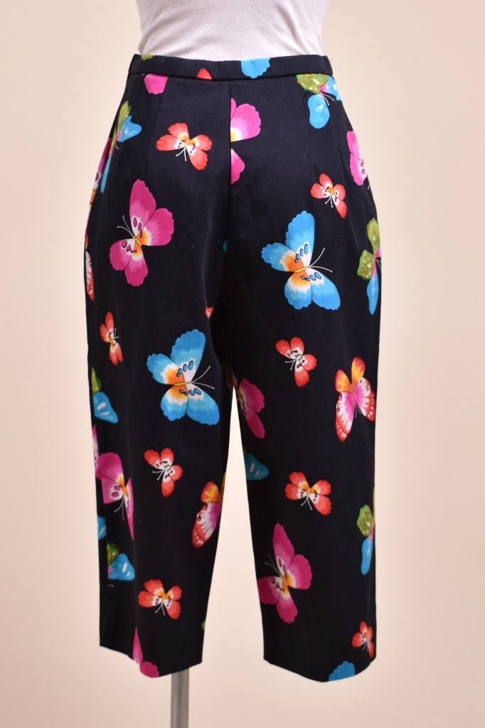Vintage Y2K black and colorful capri's are shown from the front. These capris have colorful butterflies on the front. 