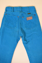 Load image into Gallery viewer, Vintage neon blue Wrangler jeans are shown in close up. 
