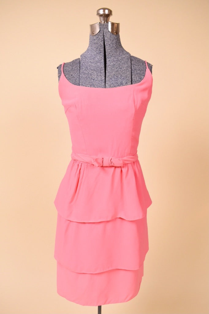 Vintage bubblegum pink party dress by Ann Barry is shown from the front. This dress has a bow belt at the waist.