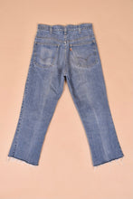 Load image into Gallery viewer, Vintage 70&#39;s Levis orange tab jeans are shown from the back. These high waisted levis have a cropped fit with raw hems.
