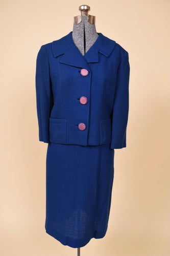 Vintage 1950's blue wool two piece skirt set by Lane Shops is shown from the front. This cobalt blue jacket has chunky lavender buttons down the front. 