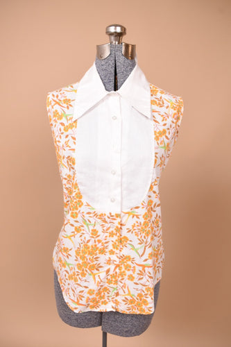Vintage 1960's orange floral bird print is shown from the front. This shirt buttons up the front.