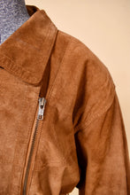 Load image into Gallery viewer, Vintage soft light brown suede 80s jacket is shown in close up. This jacket has an asymmetrical zipper up the left side of the jacket. 
