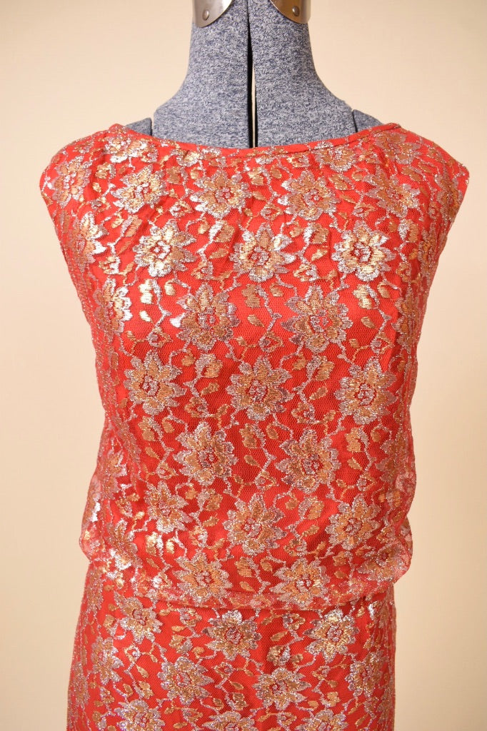 Vintage 60's red and gold metallic lace party dress is shown in close up. This dress is sleeveless. 