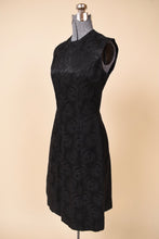 Load image into Gallery viewer, Vintage 60&#39;s black floral jacquard tunic slit sheath dress is shown from the side. This dress has a high neckline. 
