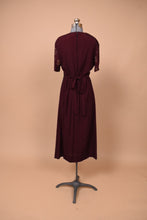 Load image into Gallery viewer, Vintage burgundy nineties grunge maxi dress is shown from the back. This dress ties in a bow at the back to cinch the waist.
