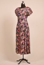 Load image into Gallery viewer, Vintage pink and purple floral rose print rayon crepe dress is shown from the side. This maxi dress has short sleeves. 
