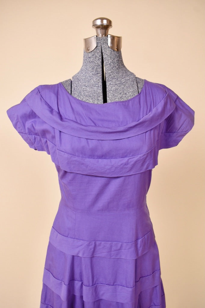 Vintage bright purple tea dress is shown from the front. This dress has a wide boatneck.