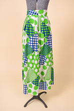 Load image into Gallery viewer, Vintage sixties green and blue patchwork print maxi skirt is shown from the back. This skirt has a fun harlequin polka dot print. 
