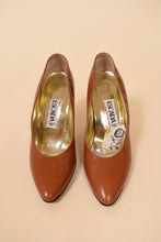 Load image into Gallery viewer, Vintage 80s caramel leather pumps are shown from the front. These designer leather heels are by the brand Escada. 
