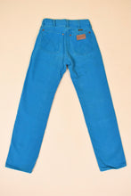Load image into Gallery viewer, Vintage 1980&#39;s turquoise jeans by Wrangler are shown from the back. 
