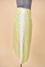 Load image into Gallery viewer, Vintage early 2000&#39;s designer Versace pencil skirt is shown from the side. This lightweight silk blend skirt has a white and green checkerboard print. 
