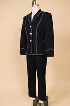Load image into Gallery viewer, Vintage designer Escada two piece pantsuit is shown from the side. This black blazer and trouser set has white contrast stitching.
