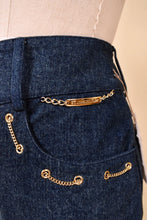 Load image into Gallery viewer, Vintage Y2K navy stretch denim bell bottom jeans are shown in close up. These jeans have little gold chains at the waistband. 
