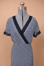 Load image into Gallery viewer, Vintage Laura Ashley calico floral print navy dress is shown in close up. This dress has a criss cross v neckline.
