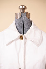 Load image into Gallery viewer, Vintage 60&#39;s Bonnie Cashin Sills white leather swing coat is shown in close up. This jacket has brass turn locks down the front.

