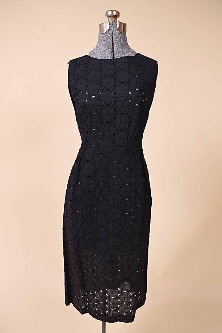 Vintage 1950's black eyelet midi length dress by Puritan is shown from the front. This dress has a high boat neckline. 