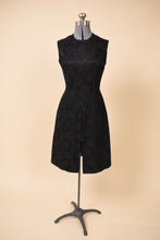 Load image into Gallery viewer, Vintage black silk jacquard 60s dress is shown from the front. This sleeveless dress has a flared skirt. 

