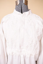 Load image into Gallery viewer, Vintage white cotton embroidered puff sleeve poet blouse is shown in close up. This blouse has a mandarin collar. 
