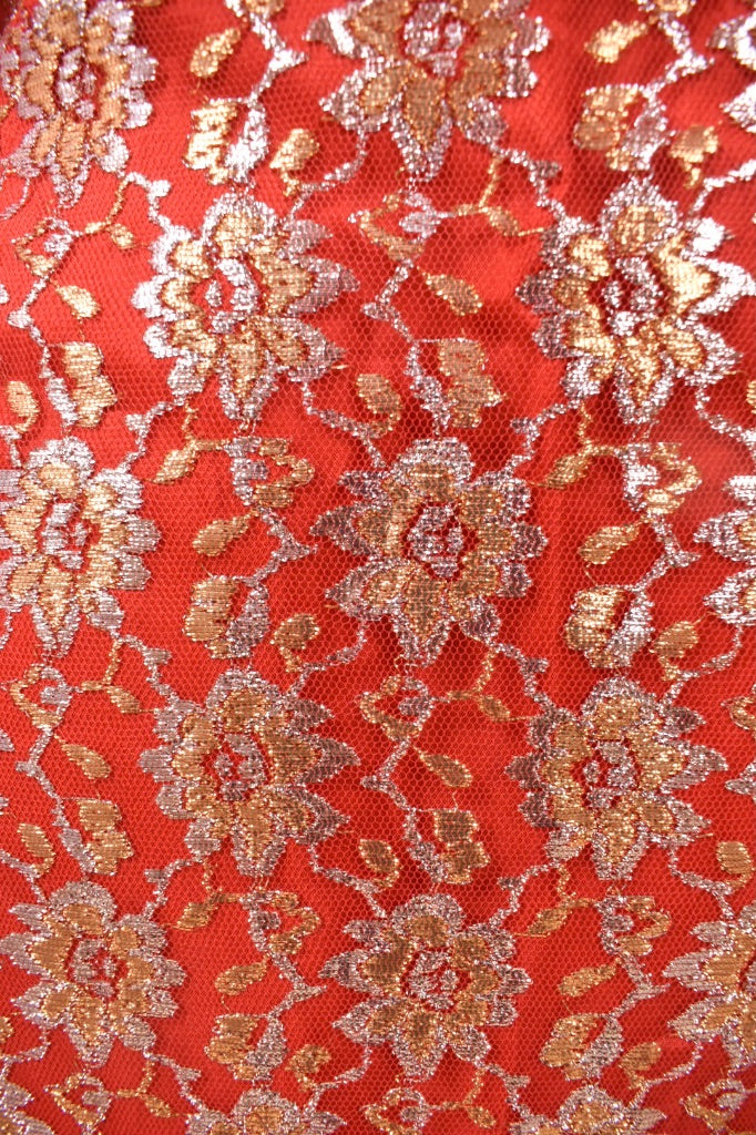 Vintage 1960's red dress with mesh lace metallic overlay is shown in close up.