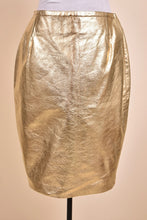 Load image into Gallery viewer, Vintage 1990&#39;s gold metallic leather skirt by Kenar is shown from the front. This skirt has a high waisted fit. 
