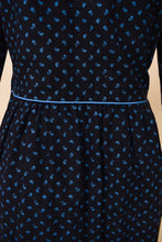 Load image into Gallery viewer, Vintage black cotton floral midi length dress by Lanz is shown in close up. This 70&#39;s dress has light blue piping at the waistline. 
