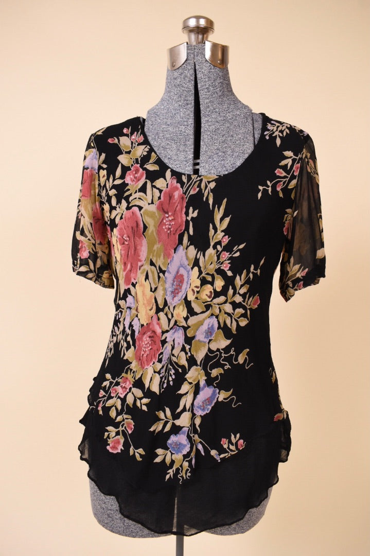 Vintage 1990's black floral print scoop neck bias cut top is shown from the front. This top has short fluttery sleeves. 