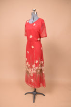 Load image into Gallery viewer, Vintage 90s red lined sheer dress is shown from the side. This dress has a white graphic floral print.
