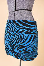 Load image into Gallery viewer, Vintage early 2000&#39;s blue and black animal print stretchy low rise mini skirt is shown from the side. 
