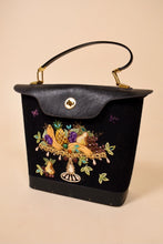 Load image into Gallery viewer, Vintage 1960&#39;s Enid Collins black leather and canvas bucket bag is shown from the front. This bag has a fruit platter embroidered on the front with gems.
