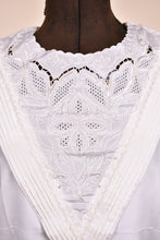 Load image into Gallery viewer, Vintage long sleeve white blouse is shown in close up. This blouse has a lace neckline with a cutout detail. 

